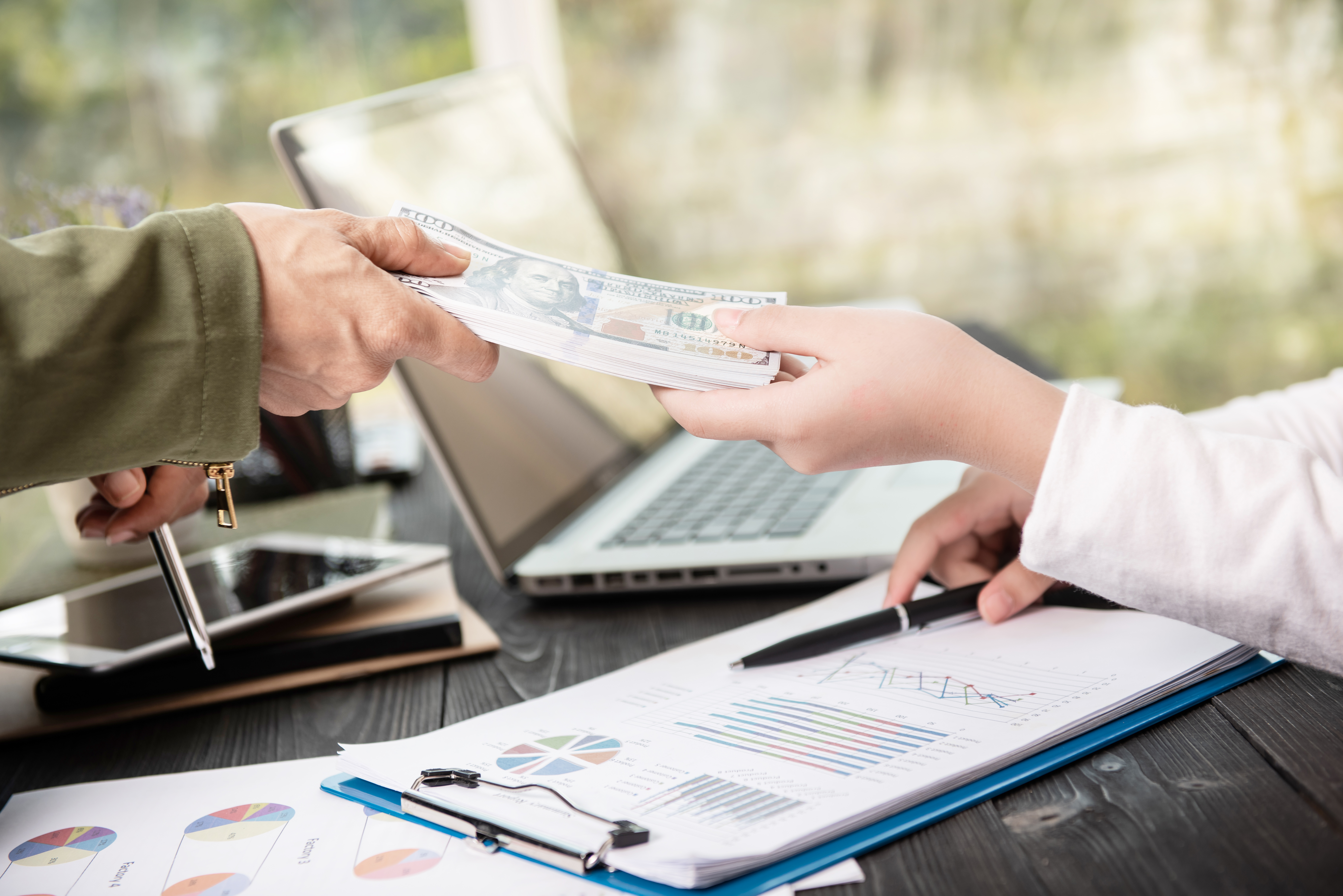 businessman-giving-money-his-partner-while-making